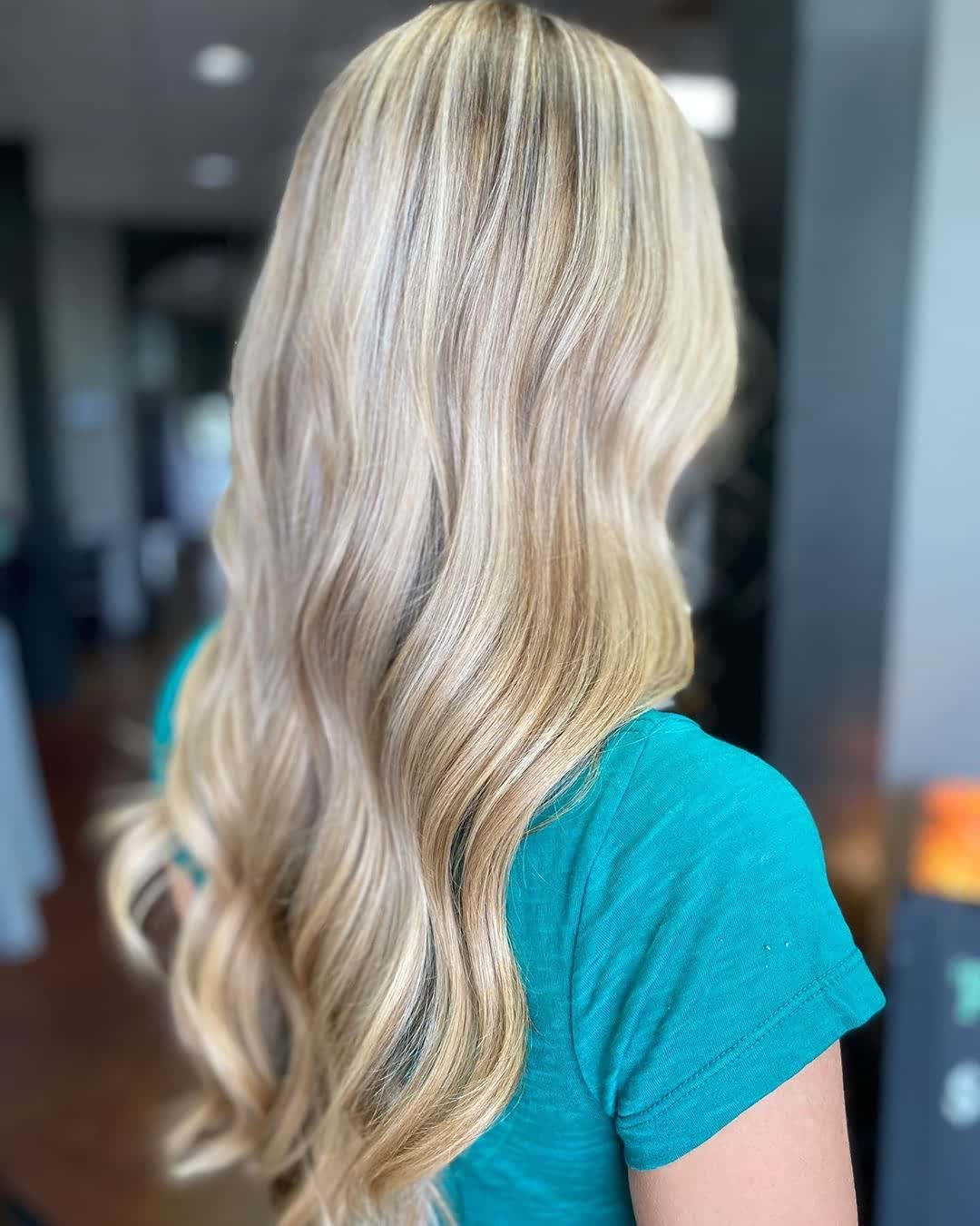 Długie blond włosy z szerokimi falami Długie blond włosy ułożone w duże gładkie fale