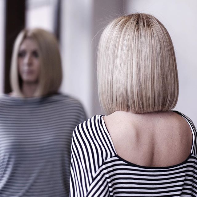 Popielaty blond bob z równym tyłem Popielaty blond bob pokazany od tyłu w lustrze