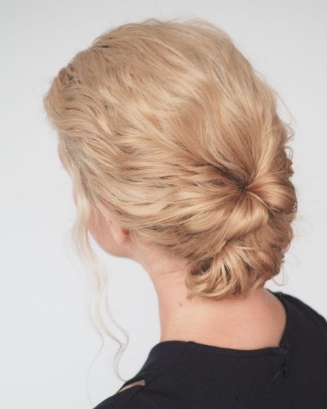 Niski blond kok ze skręconych pasm Niski blond kok ze skręconych pasm i luźnym lokiem przy twarzy