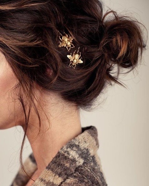 Messy bun ze złotymi spinkami Luźny ciemny kok z dekoracyjnymi złotymi spinkami