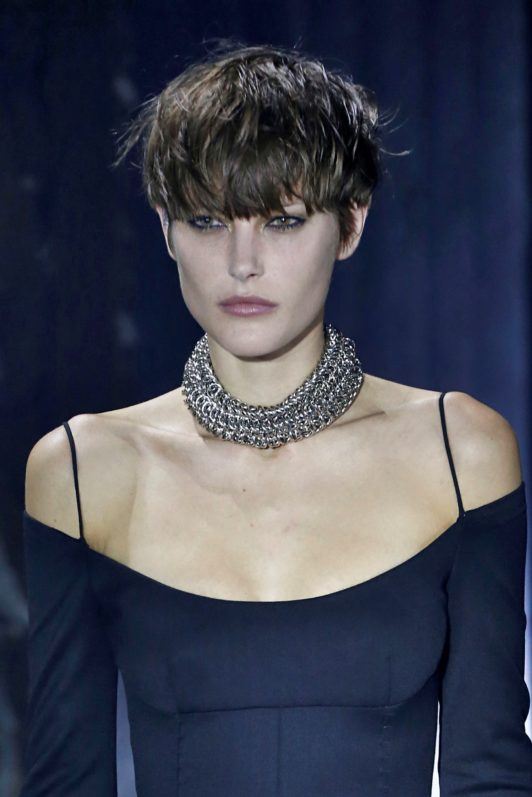 Postrzępiony androgyniczny crop z długą grzywką Krótka postrzępiona fryzura z długą grzywką zasłaniającą czoło